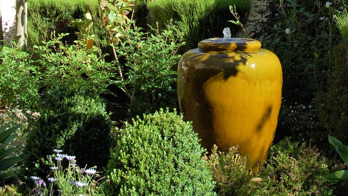 Decorative fountain surrounded by greenery in a garden