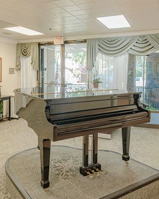 A grand piano in a well-lit common area