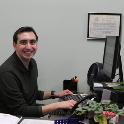 Staff member smiling at their desk