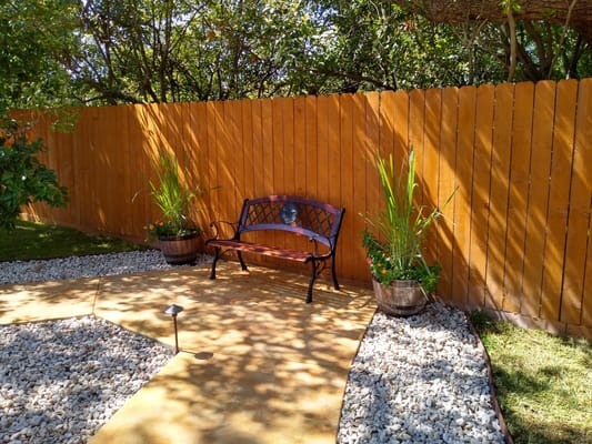 A peaceful outdoor seating area with a bench and plants