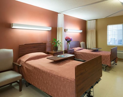 A cozy resident room with two beds and decor