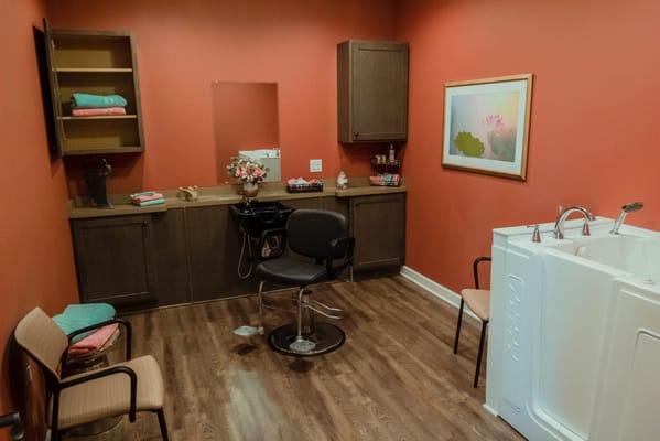 Interior of a salon space with seating and a tub.