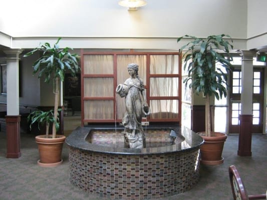 Indoor water fountain in a common area with greenery