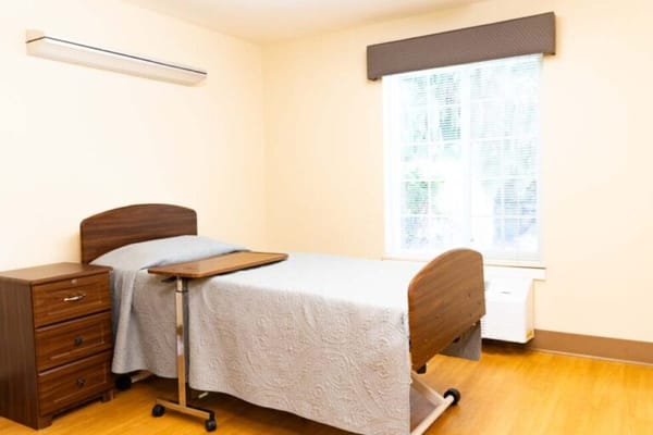 Bright private resident room with a bed and window