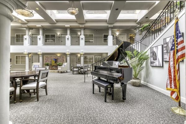 Spacious common area with a piano and seating