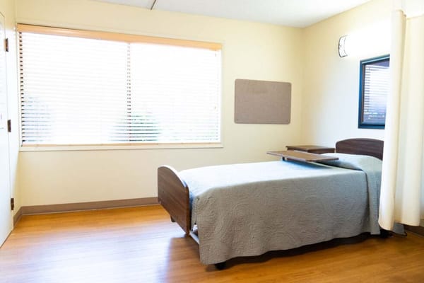 A private resident room with a bed and window