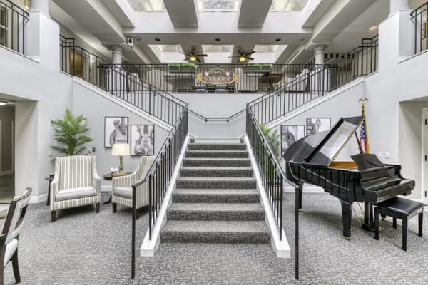Interior view of a spacious lobby with stairs and piano