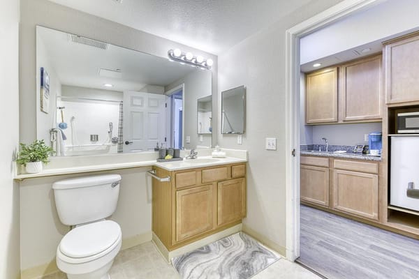 Modern bathroom with vanity and kitchenette visible