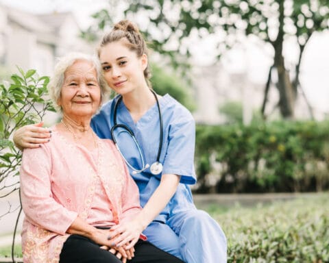 A caregiver with an elderly resident outdoors
