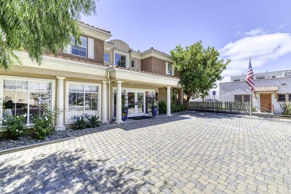 Front entrance of a senior living facility with landscaped area