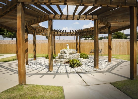 Outdoor garden space with wooden pergola and stone features