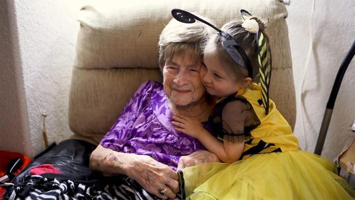 Senior resident smiling with a young girl in costume