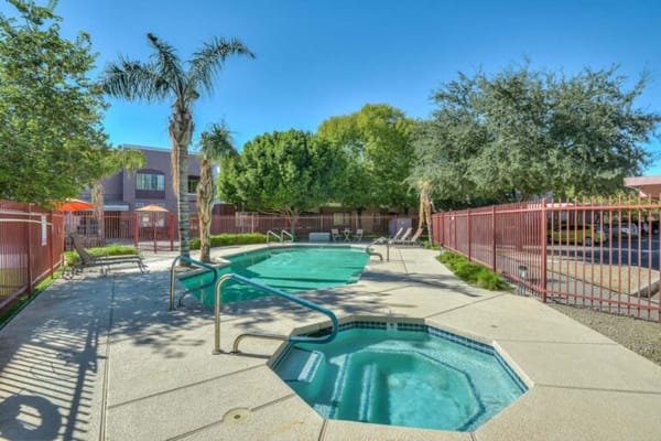 Outdoor pool area with seating and palm trees