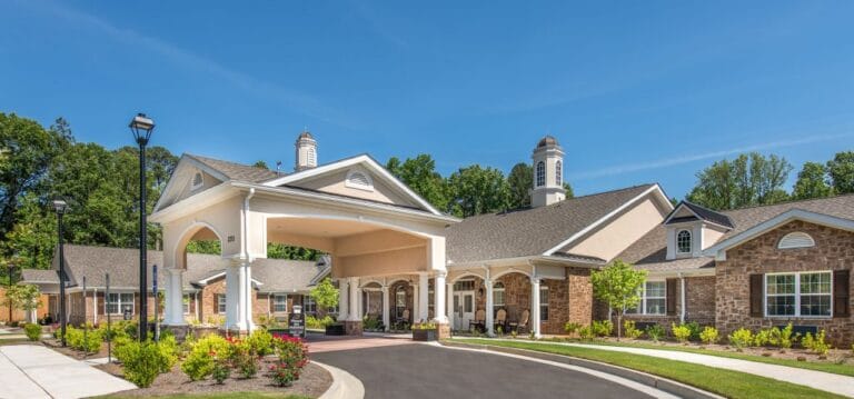 Exterior view of a senior living facility with gardens