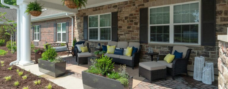 Outdoor seating area with plants and comfortable chairs