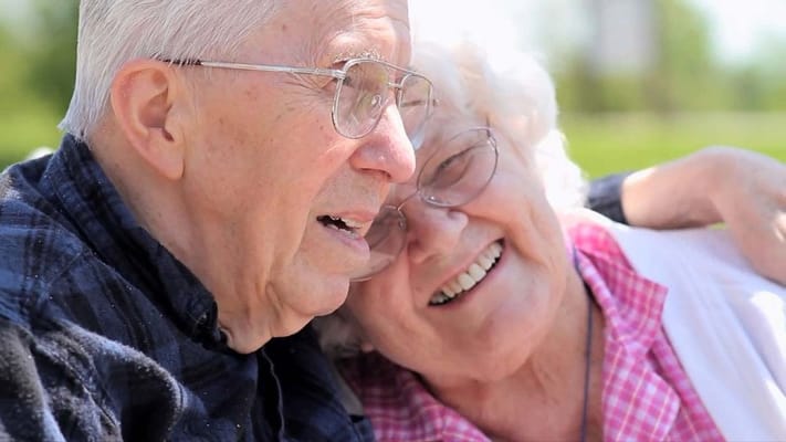 Two seniors smiling together outdoors