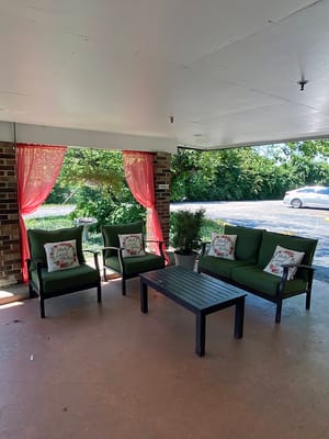 Outdoor seating area with green chairs and cushions