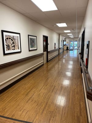 Well-lit hallway with framed pictures on the walls