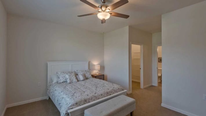 Bright and inviting resident bedroom with a ceiling fan