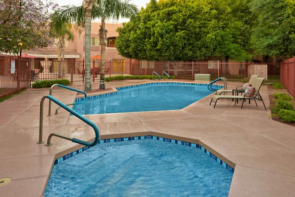 Outdoor pool area with lounge chairs and palm trees