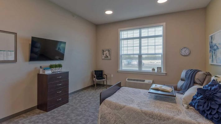 Bright private room with a bed and television