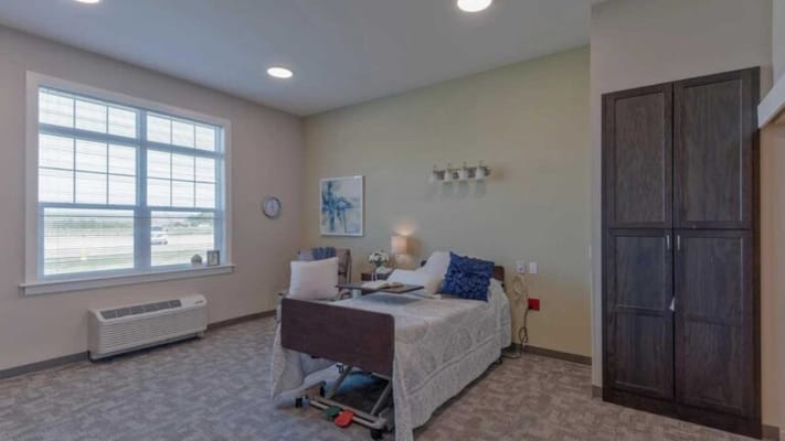 A well-furnished private resident room with a bed and window