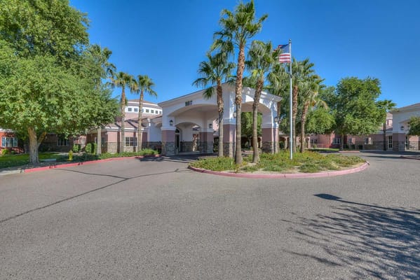 Entrance of a senior living facility with palm trees