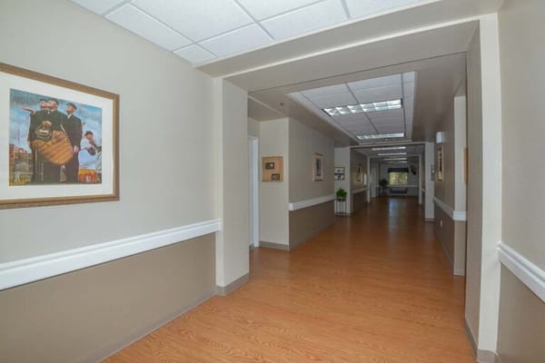 A hallway with framed artwork and wooden flooring