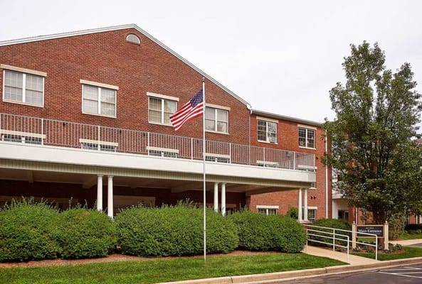 Exterior view of a senior living facility with flag