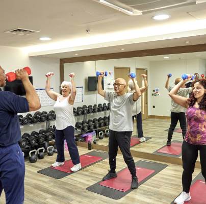 Seniors exercising in a fitness room with weights