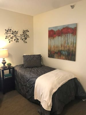 Cozy resident room with bed and artwork