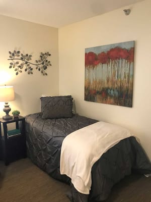 Cozy resident room with bed and artwork