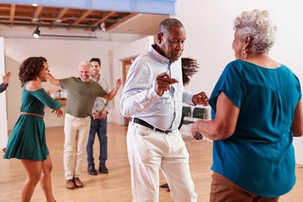 Residents and staff dancing in an activity space