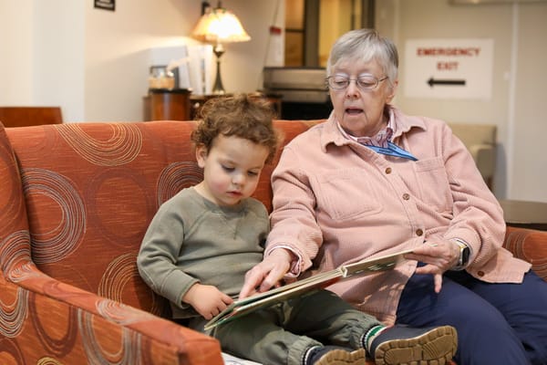 Senior reading with a child in a cozy lounge