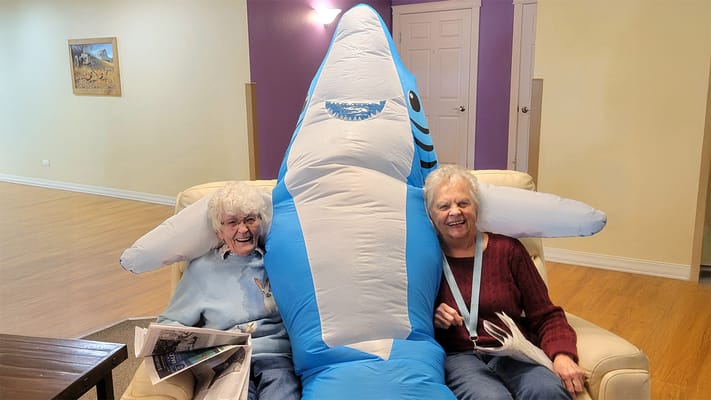 Two residents posing with a large inflatable shark