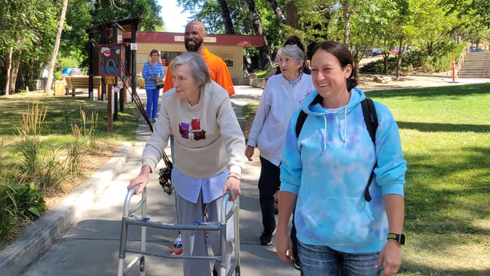Residents and staff enjoying a walk in the garden