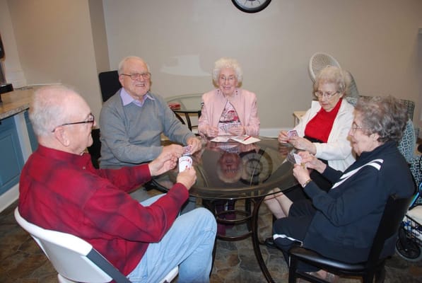 Residents playing cards at a round table