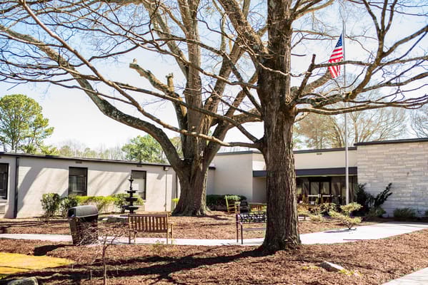 Outdoor area with trees and seating near the facility
