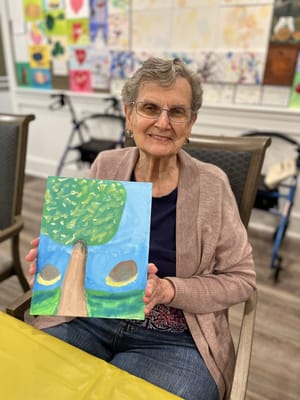 Resident holding a painting in a common area