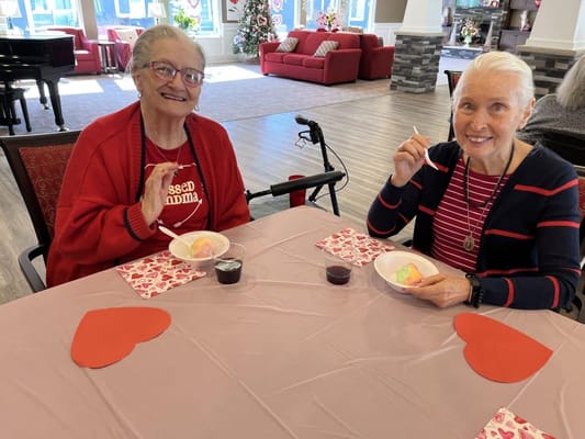 Two residents enjoying dessert in a common area