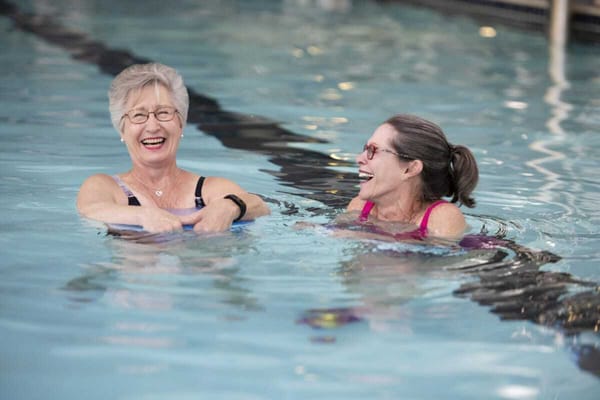 Two women enjoying water activities in a pool