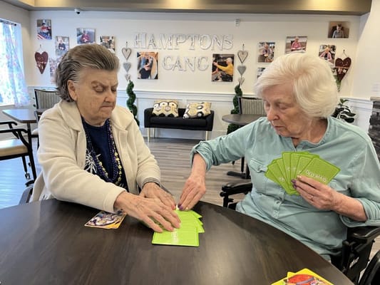 Two residents playing cards in a common area