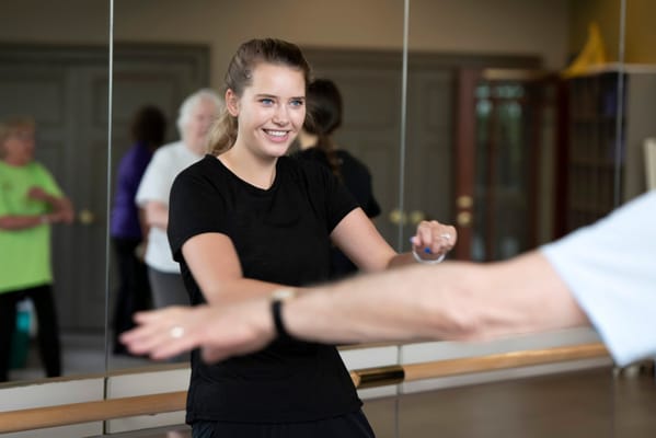 Instructor assisting a resident in a fitness class