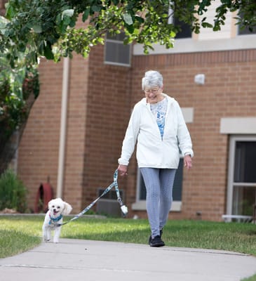 Resident walking a small dog outside