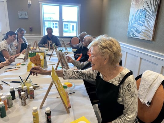 Residents participating in a painting activity in a common area