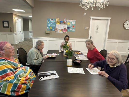 Residents engaging in a coloring activity around a table