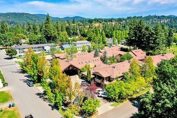 Aerial view of the assisted living facility with trees and parking lot
