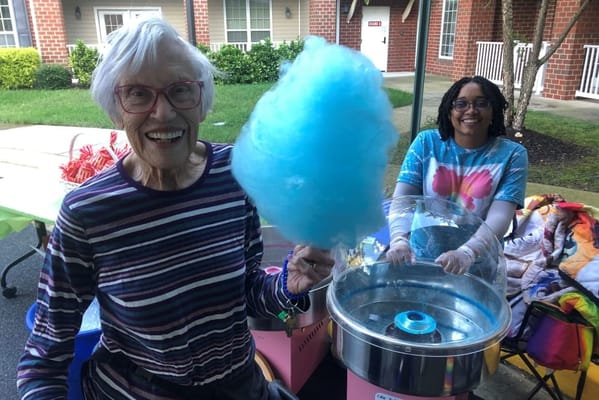 Happy resident enjoying cotton candy at an outdoor event