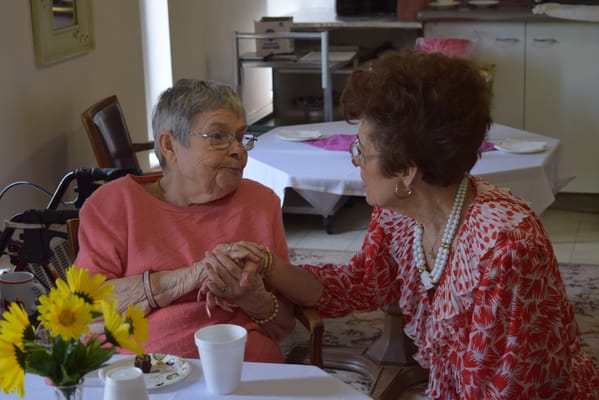 Two residents enjoying a conversation in a bright room