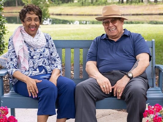 Two residents enjoying a moment on a bench in the garden